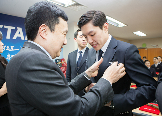 이스타항공 김정식 대표가 인턴승무원에게 승무원 뱃지를 달아주고 있다.